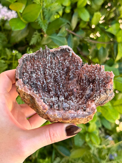 Another angle of the shallow geode, the pattern interrupted by a crack left of center and swirling orange and white agate growth.