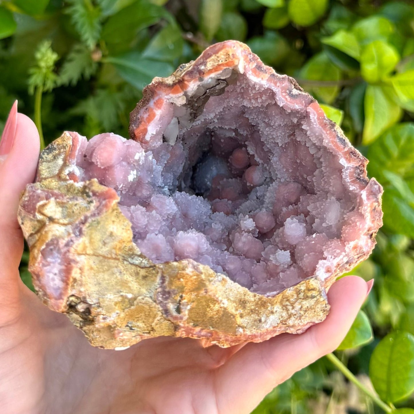 Looking straight into the bottom of the conical geode, several sphere-like forms in white and orange visible.