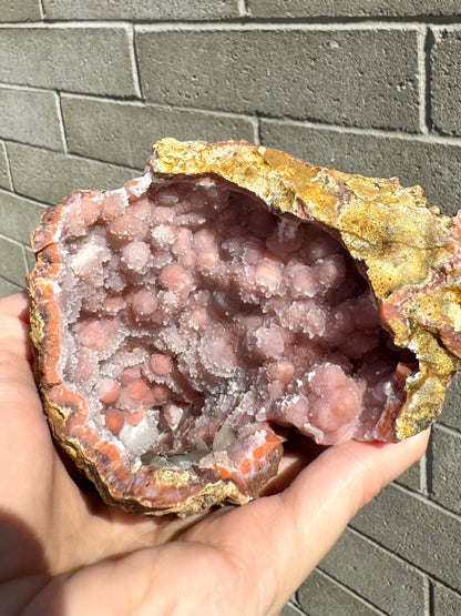 Looking down into the geode, with spherical orange and white forms near the tip