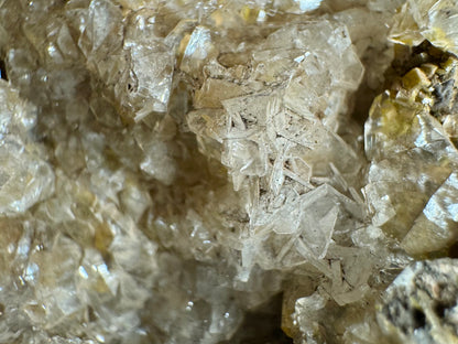 Detail of flat hexagonal platelets of colorless crystal intersecting in clusters