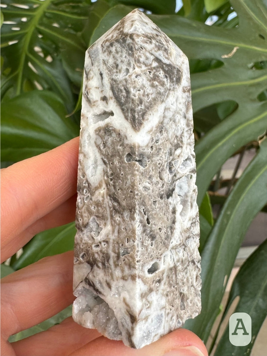 Option A, angled view of two sides, with a band of white through the mottled gray material pierced with small holes. There is a good-sized cavity in the base.