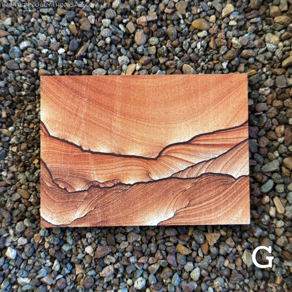 Option G, a rectangular slab with two bold dark iron bands across the middle, curved and scalloped. The sandstone is a darker brown tone below the lower line, and a more vibrant orange above, with very good curving layering. Above the top line, light layers sweep across in a broad curve, appearing like sky over rows of hills.