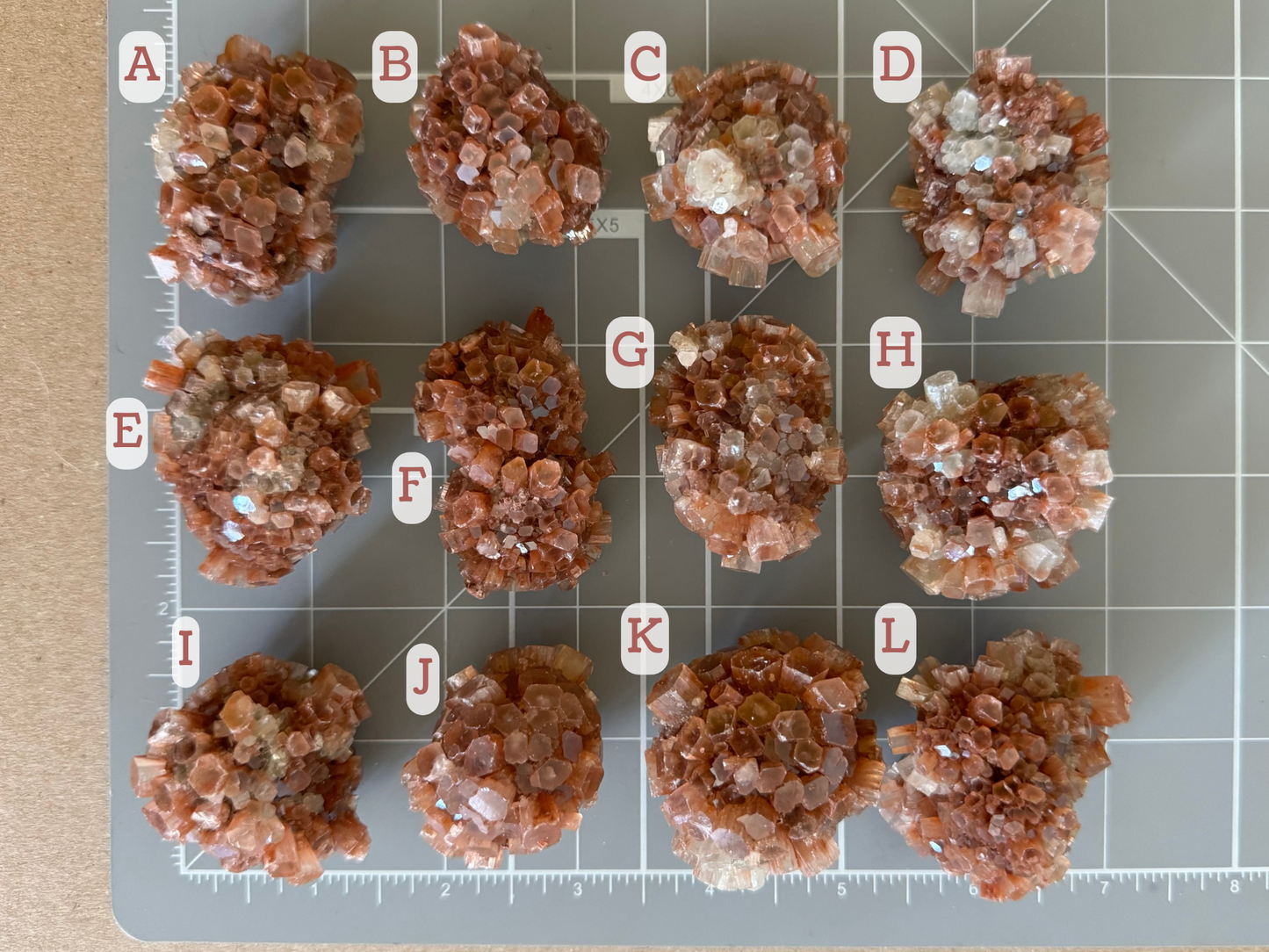 Scale image showing the options spread on a measuring mat and labeled. The approximate size of each is: A, 1.5 inch; B, 1.25 inch; C, 1.25 inch; D, 1.5 inch; E, 1.75 inch; F, 1.75 inch; G, 1.5 inch; H, 1.25 inch; I, 1.25 inch; J, 1.5 inch; K, 1.75 inch; L, 1.75 inch